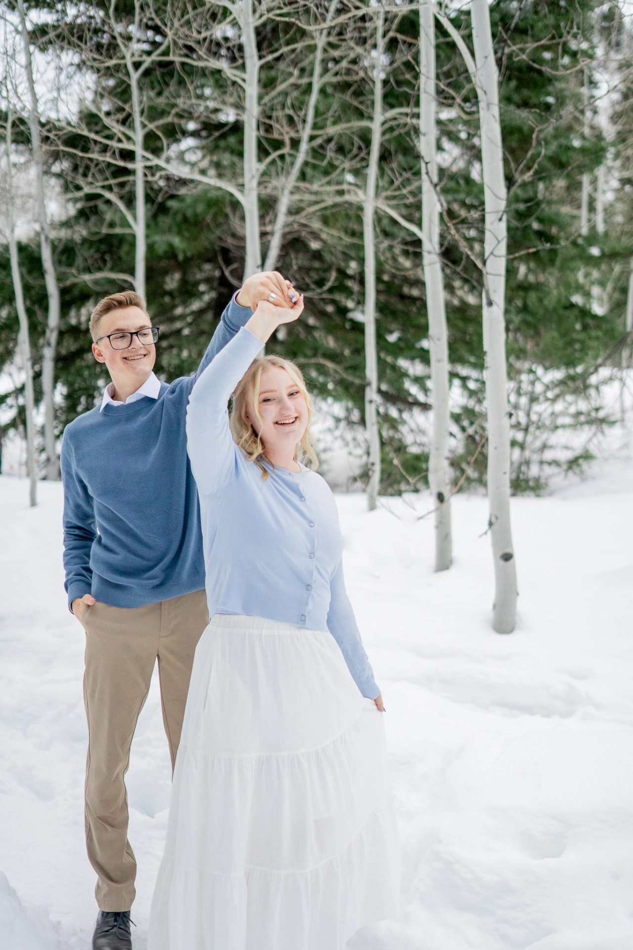 Aaron playfully spins Emily in front of him.