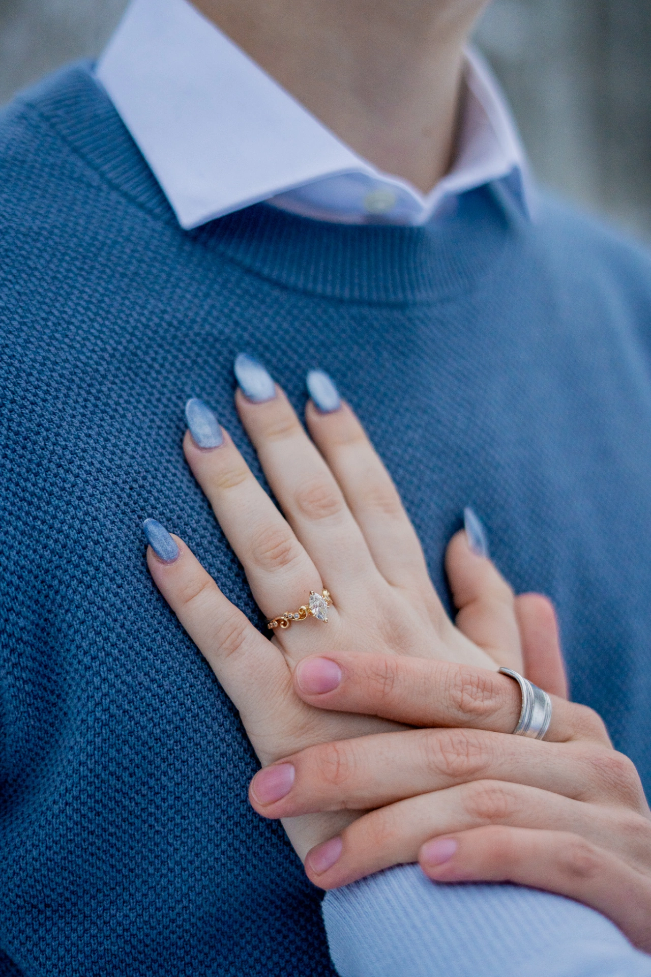 Emily's hand is placed on Aaron's chest with Arron's hand on hers. Their engagement rings are prominent and beautiful.