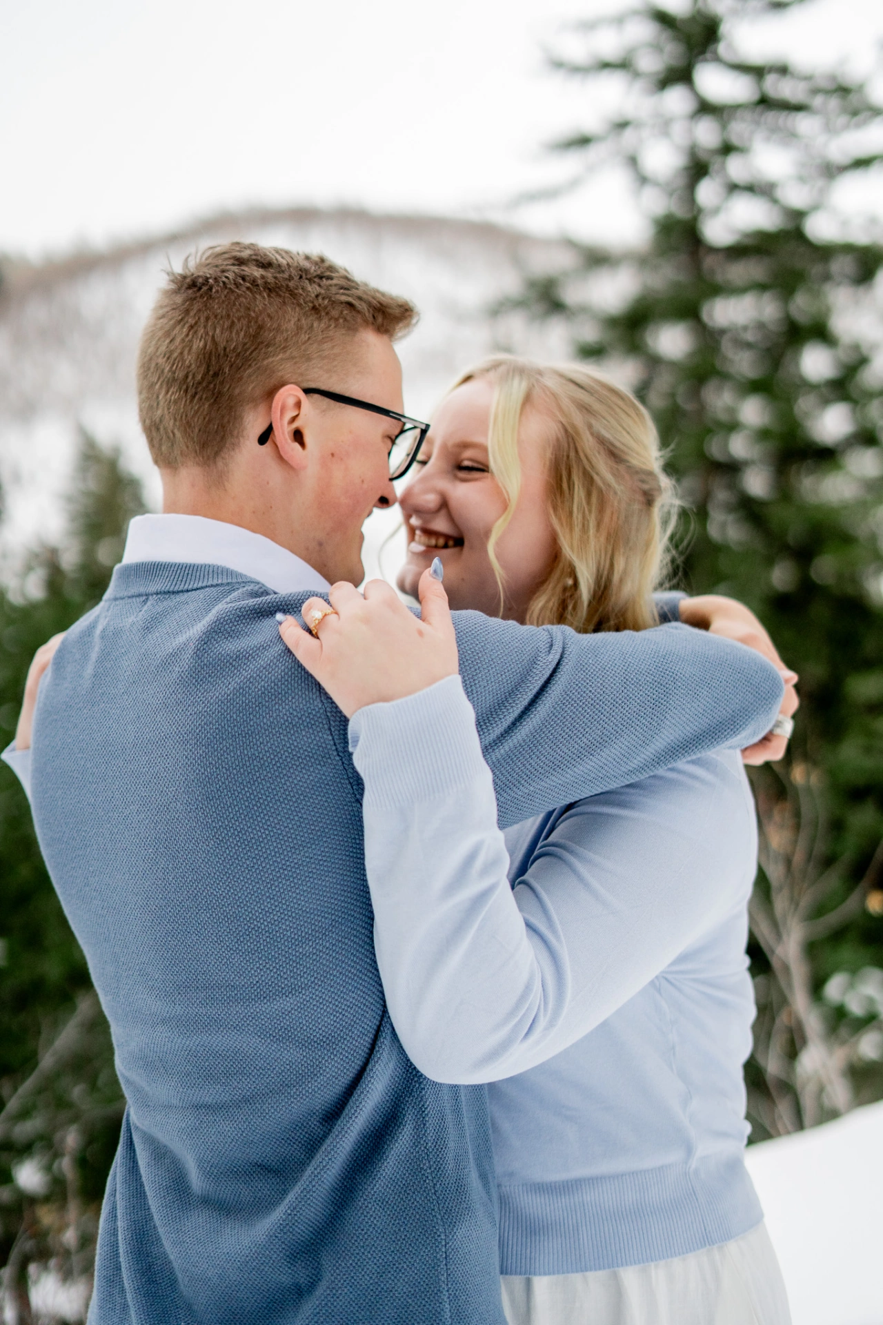 Aaron and Emily embrace each other while smiling and locking eyes.